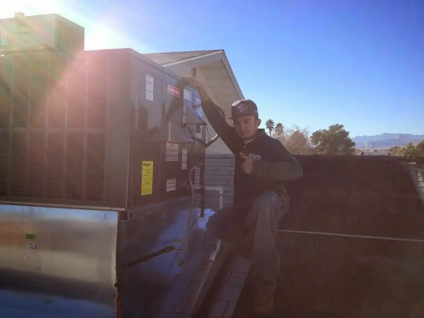 HVAC technician performing Boiler Repair on a rooftop unit in Sylacauga